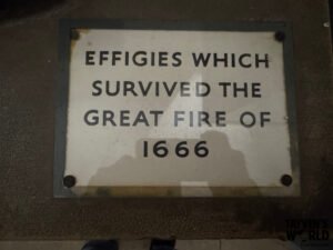 Plaque reading “Effigies Which Survived the Great Fire of 1666,” mounted on a stone surface with a Tayven’s World watermark in the corner.