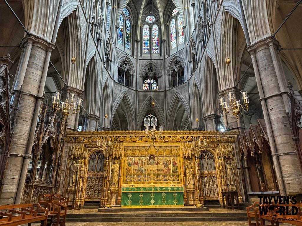 The High Altar inside Westminster Abbey, with ornate stonework, gilded details, and surrounding seating used during coronations.