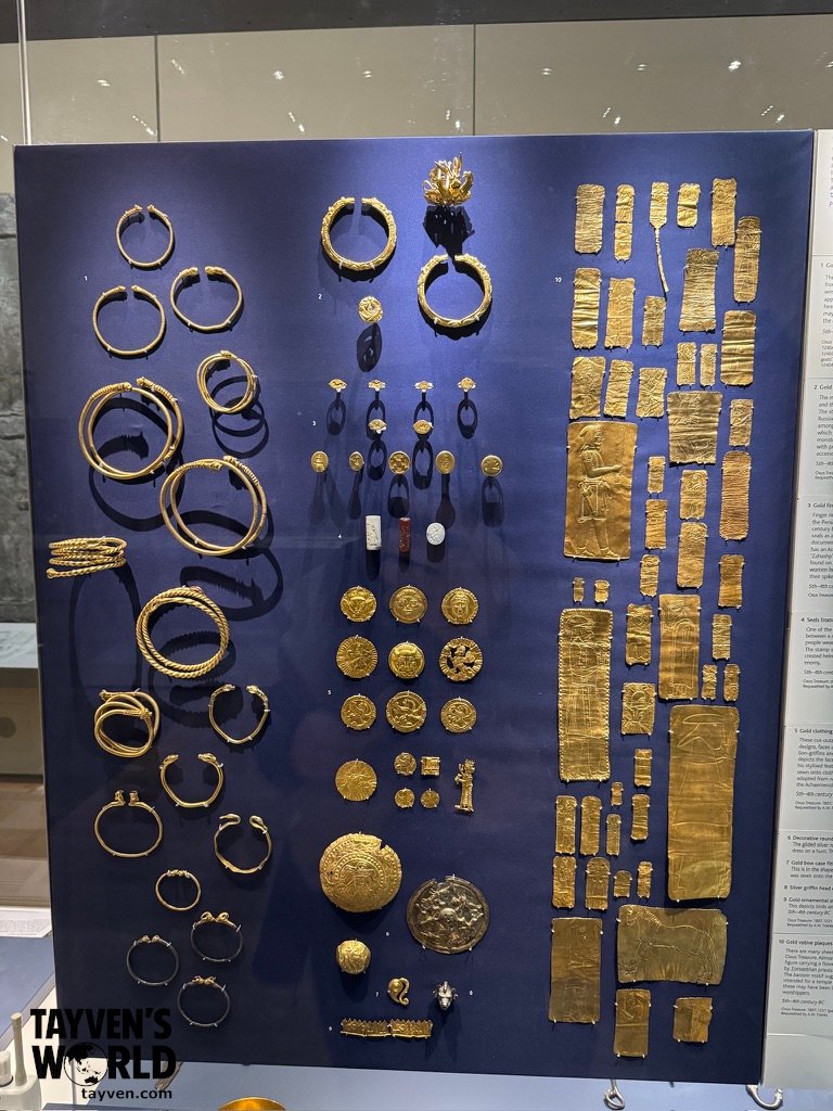 Ancient Gold Artefacts Exhibit Collection of ancient gold bracelets, rings, plaques, and ornaments arranged in a museum display.
