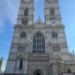 Westminster Abbey’s west front with twin Gothic towers on a clear blue morning.