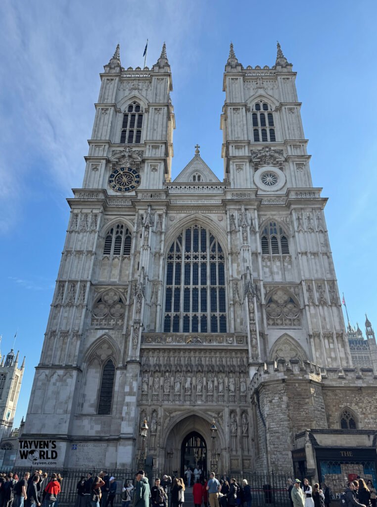 Westminster Abbey’s west front with twin Gothic towers on a clear blue morning.