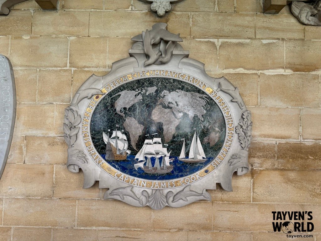 Stone plaque at Westminster Abbey featuring a circular mosaic of a world map with sailing ships, commemorating Sir Francis Drake and Captain James Cook.