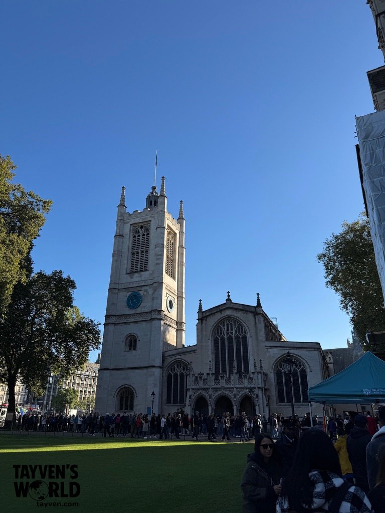 St Margaret’s Church in Westminster with a crowd lining up outside on a clear blue morning.