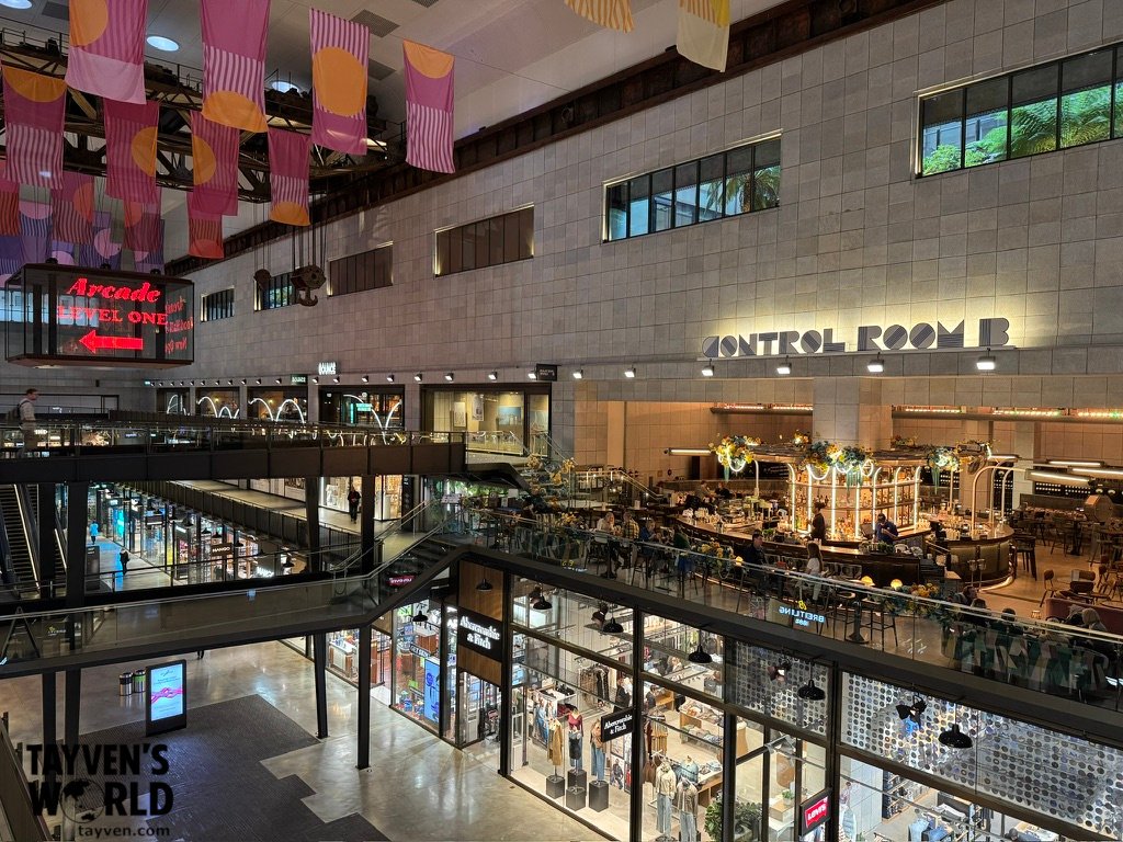 Interior of Battersea Power Station showing Control Room B bar and neon arcade signage.