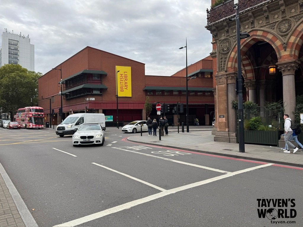 Street view of British Library and St Pancras Renaissance Hotel in London with cars and pedestrians.