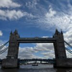 Wide view of Tower Bridge over the River Thames with reflections on the water.