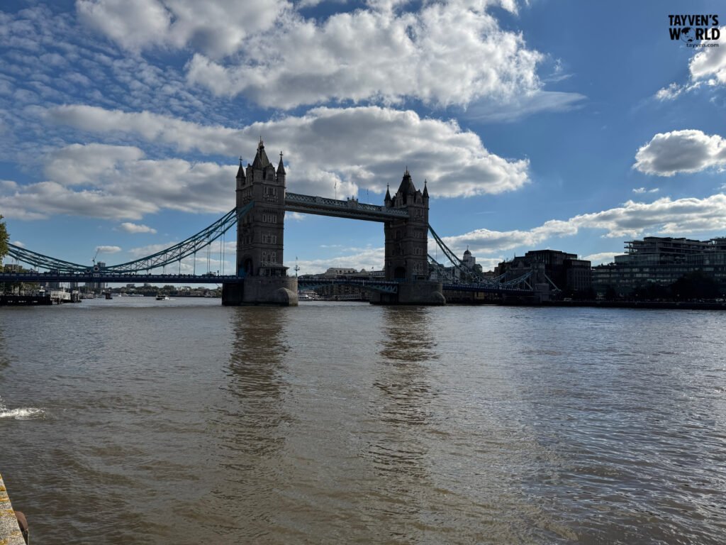 Tower Bridge spanning the River Thames with boats and pedestrians visible below.