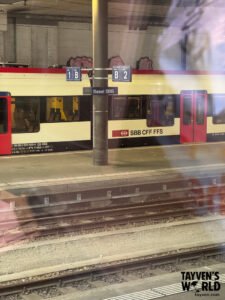 Swiss train at Basel SBB platform with signage and tracks in view.