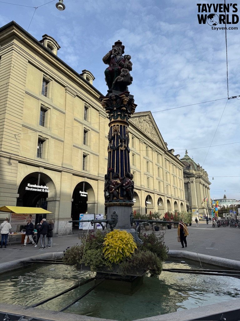 Ornate fountain in Bern with colorful statues and water flowing into a circular basin.