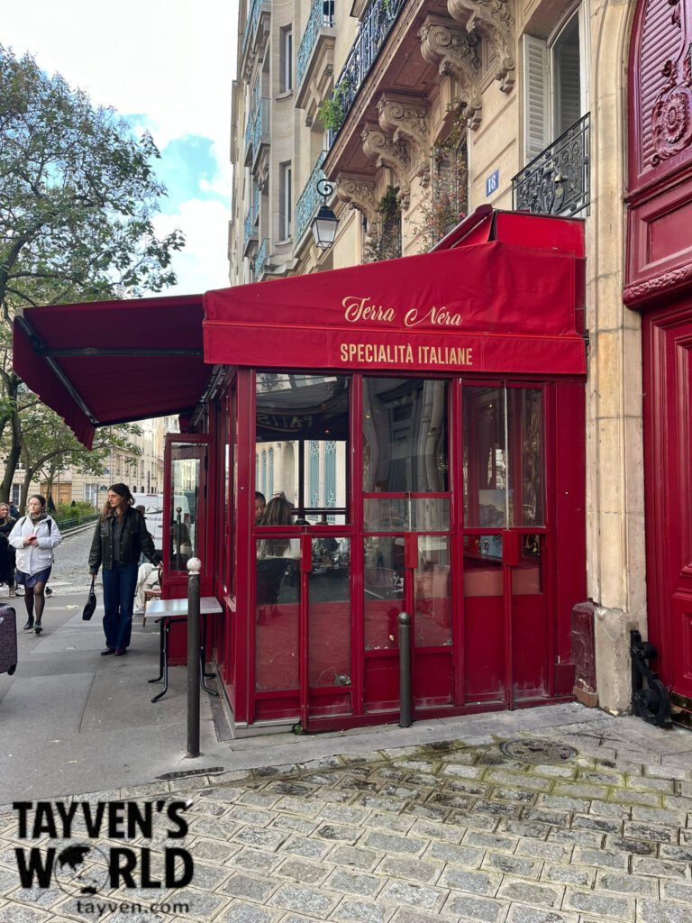 Red‑awning Italian restaurant Terra Nera on a Paris street corner.
