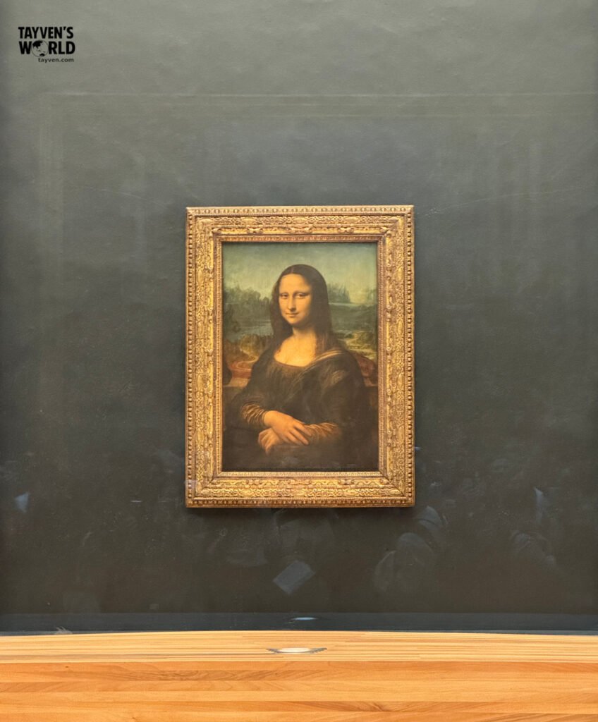 The Mona Lisa painting by Leonardo da Vinci displayed in the Louvre Museum.
