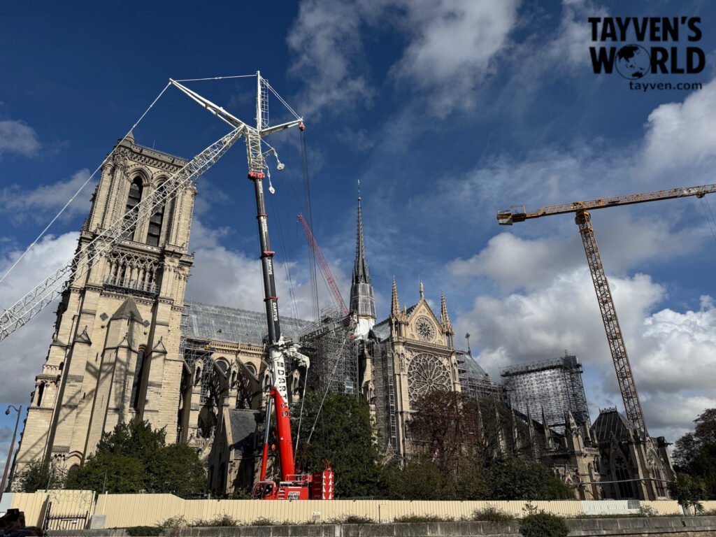 Notre‑Dame Cathedral surrounded by cranes and scaffolding during restoration.