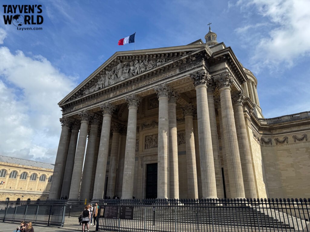 Panthéon building in Paris with French flag flying above its neoclassical columns.