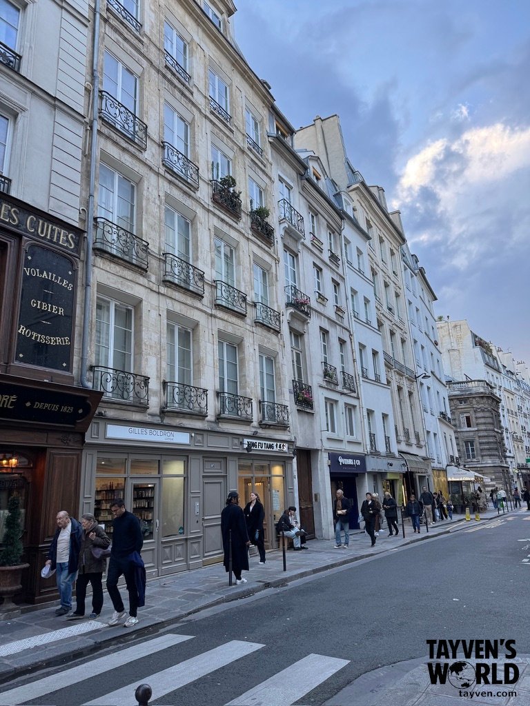 Paris street lined with historic buildings and wrought‑iron balconies.