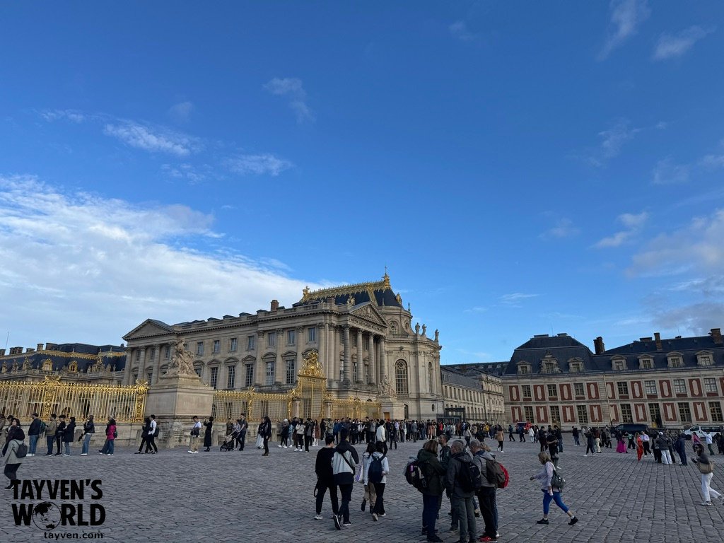 Ornate palace façade and golden details in the main courtyard of Versailles.