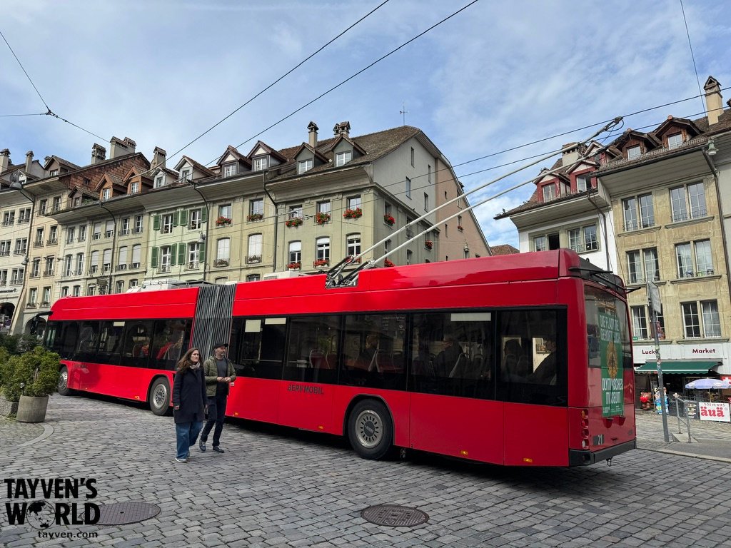 Red Bernmobil trolleybus driving through Bern’s old town