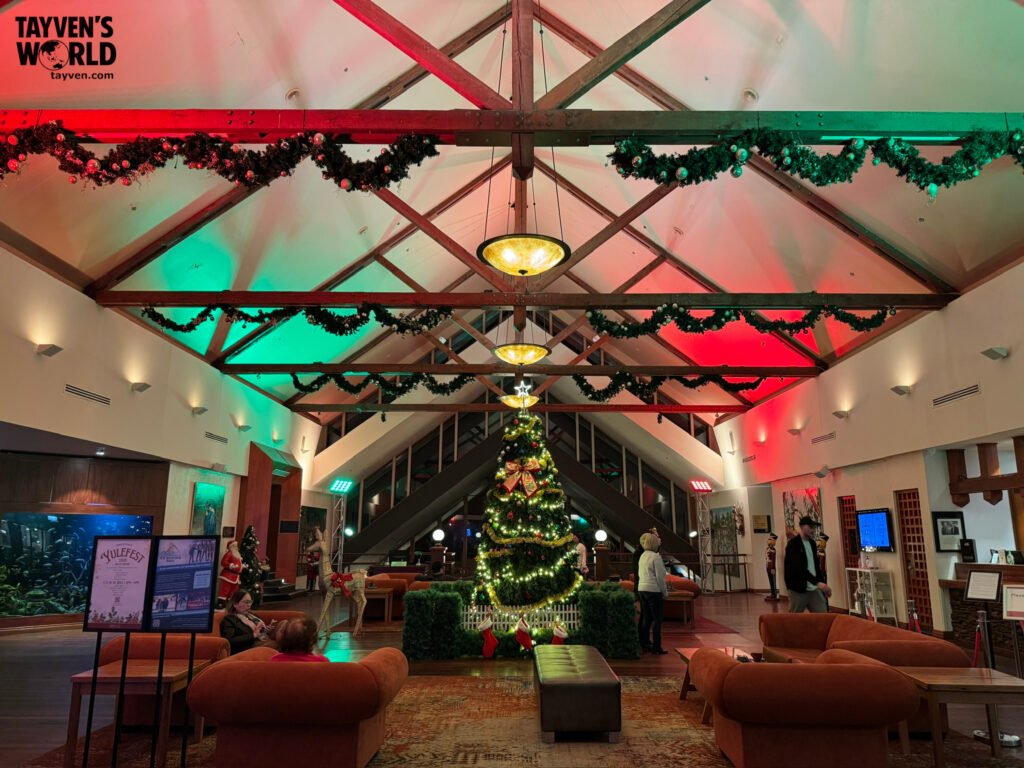 Festive hotel lobby with Christmas tree, garlands, and red‑green lighting at Fairmont Resort.
