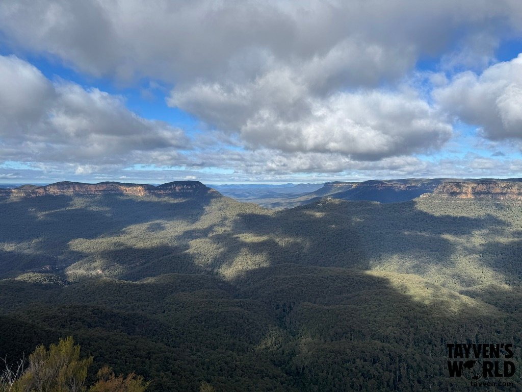 Forested mountain ridges and valleys under a cloudy sky in the Blue Mountains.