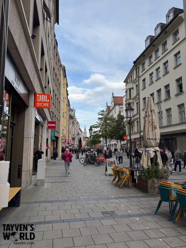 Busy pedestrian shopping street with cafés and historic buildings in central Munich
