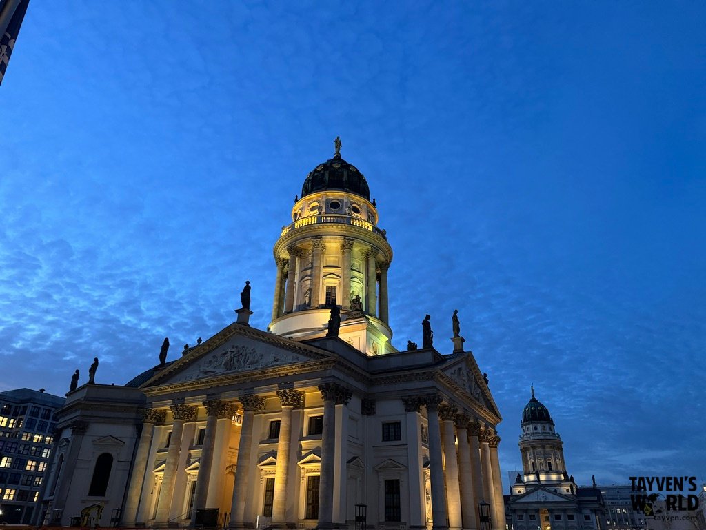 Illuminated French Cathedral at Gendarmenmarkt beneath a deep blue evening sky