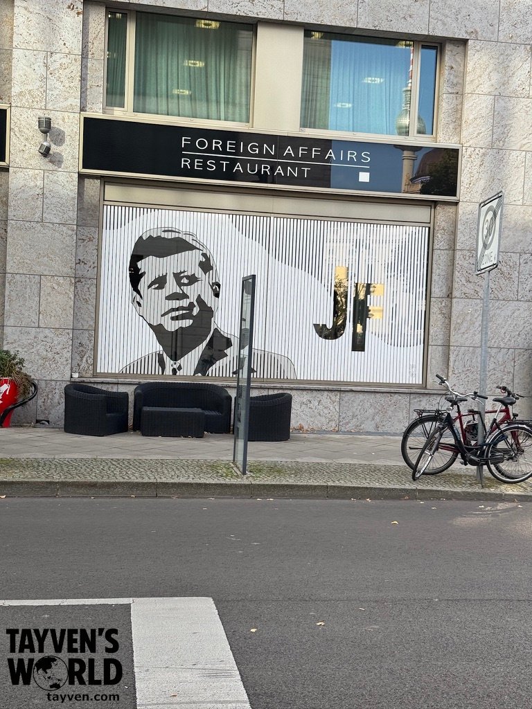 Foreign Affairs Restaurant window featuring a large image of John F. Kennedy in Berlin